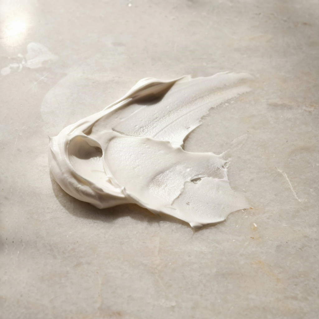Close-up texture swatch of a moisturizing cleanser showing a thick milky lotion consistency